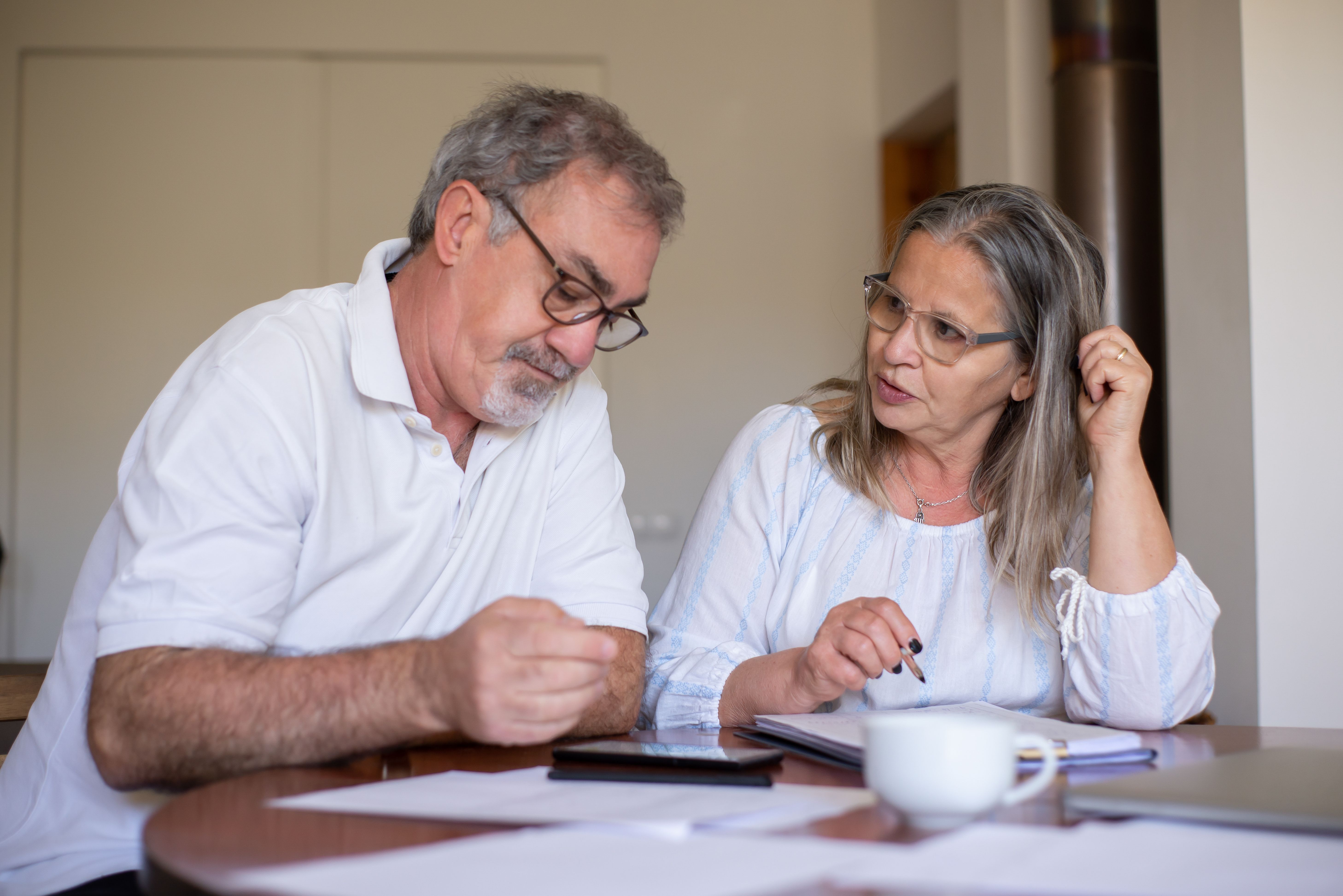 Un couple de seniors partage un moment convivial autour d'une table basse dans leur salon